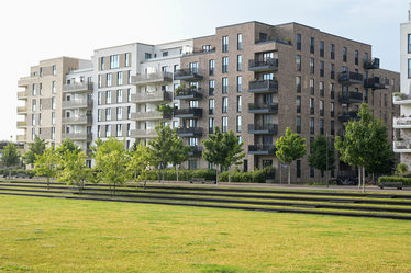 Breite, grüne Stufen am Parkrand schaffen den nötigen Höhenunterschied, um bei Starkregen temporär Wasser einzustauen